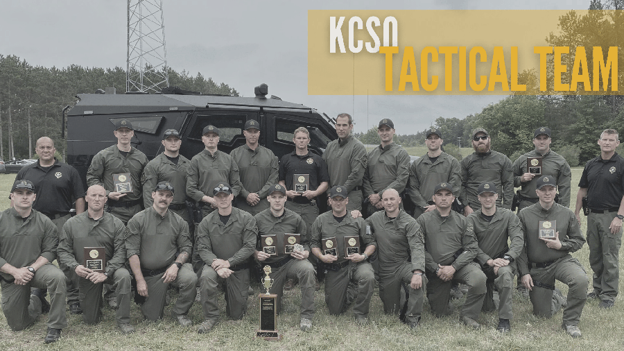The full KCSO tactical team stands in front of one of their vehicles - Several of the officers hold awards